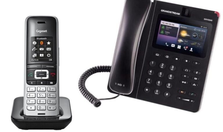 Telefon bezprzewodowy Gigaset w czarno-srebrnej obudowie na podstawce oraz czarny telefon stacjonarny Grandstream GXV3240 z kolorowym wyświetlaczem i słuchawką przewodową.